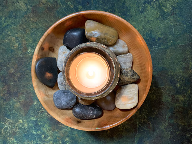 candle in bowl of stones