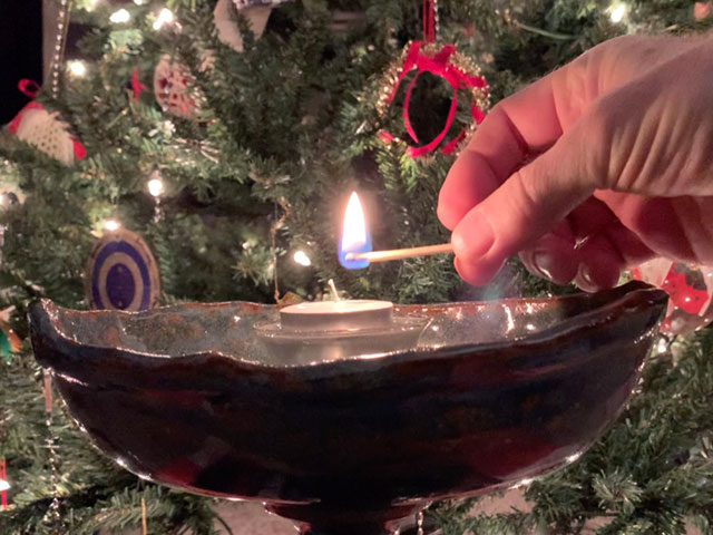 lighting candle in front of tree
