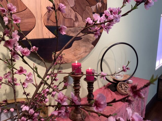 altar with pink blossoms and red candles