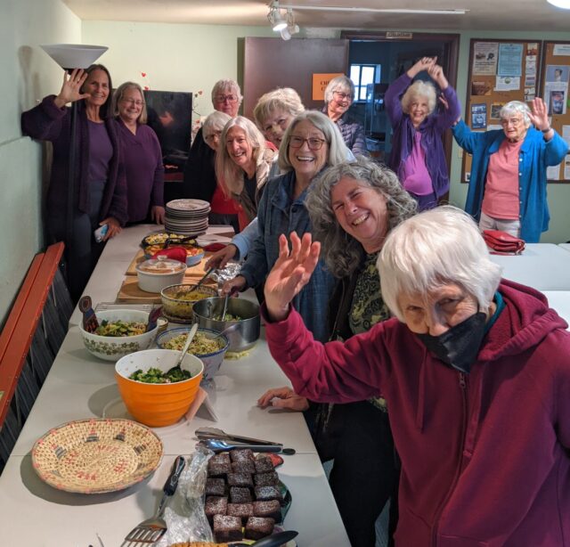 Women at potluck, waving 