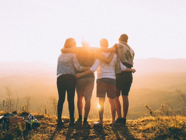 people standing with arms around each other