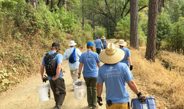 volunteers with trash buckets on hiking trail