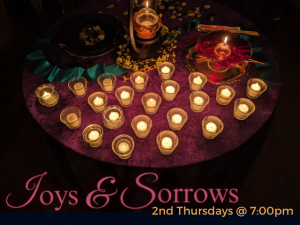 table of lit tea candles in small glass candle jars on round table with maroon table cloth in dark room service info: "Joys & Sorrows 2nd Thursdays @7:00pm"