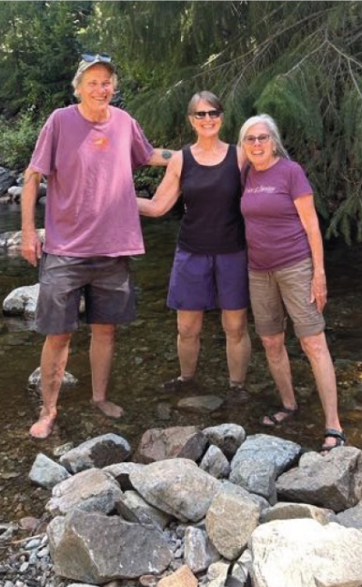Catz Forsman, Gwen Eymann, and Corrie Silva standing in a river